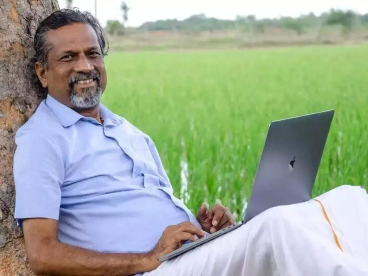 Man working on a laptop in a field representing Zoho's data centre project