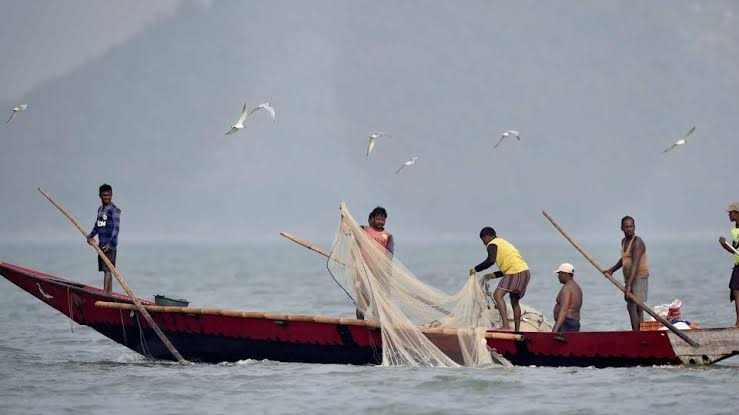 Fishermen casting nets on Chilika Lake at sunrise